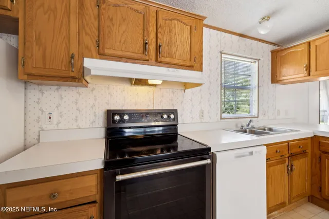 a kitchen with stainless steel appliances granite countertop a sink stove and cabinets