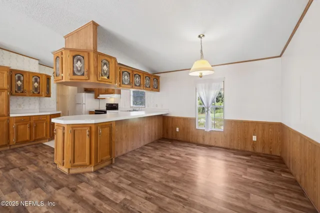 a kitchen with stainless steel appliances granite countertop a sink cabinets a stove and a wooden floors