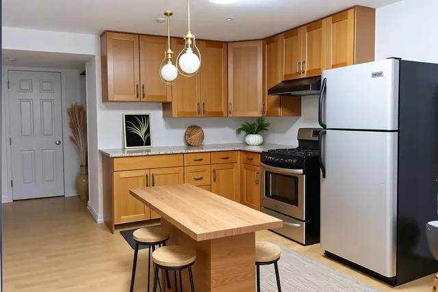 a kitchen with stainless steel appliances a refrigerator a stove a sink and a microwave