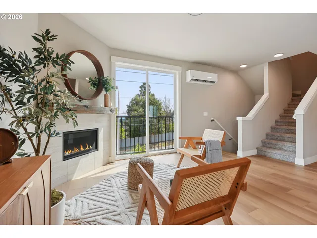 a living room with furniture a fireplace and a floor to ceiling window