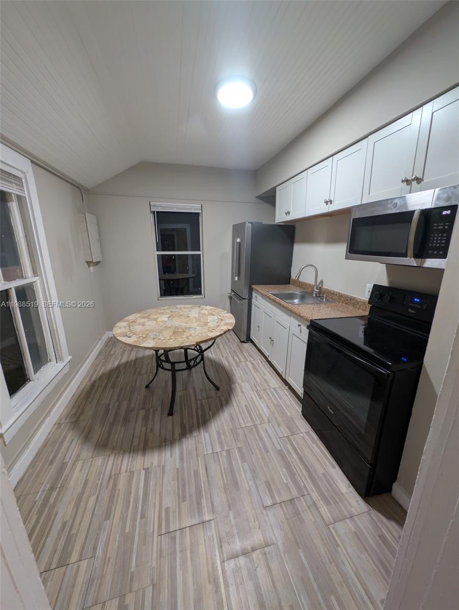 700 Boston Avenue, Unit B Fort Pierce, FL 34950 - Photo 10 of 12 a living room with stainless steel appliances kitchen island granite countertop wooden floors a stove and a sink