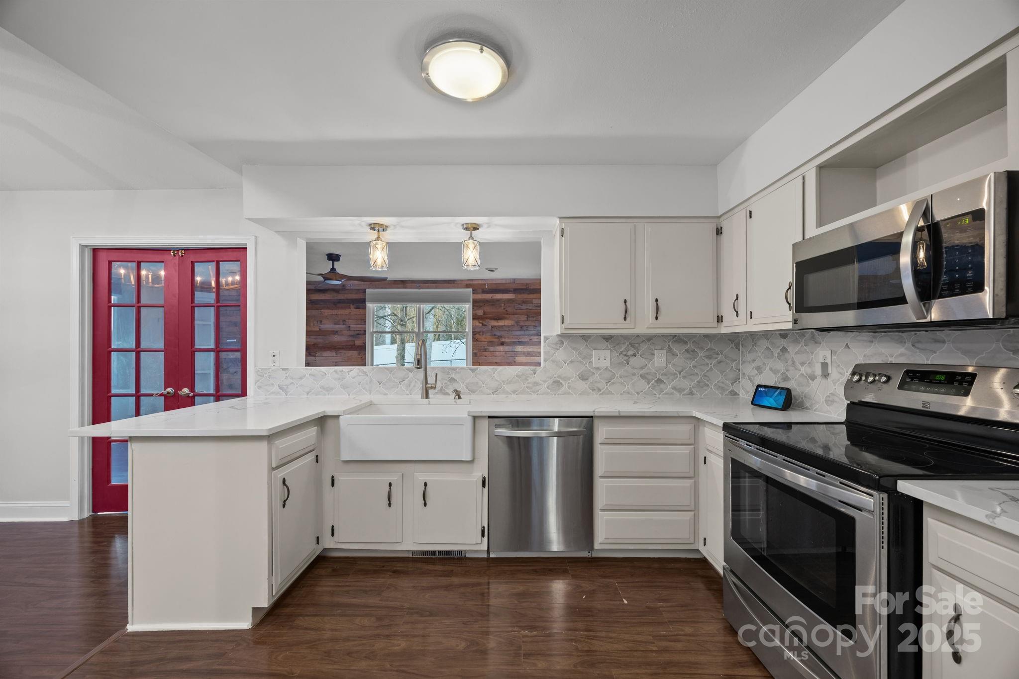 17 Berry Lane Fletcher, NC 28732 - Photo 9 of 47 a kitchen with stainless steel appliances granite countertop a stove top oven a sink dishwasher and a microwave oven with wooden floor