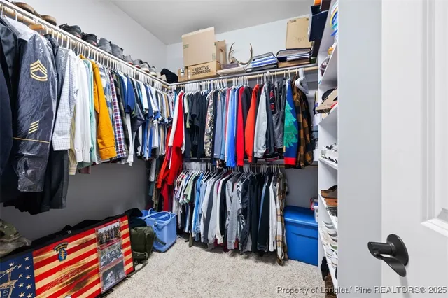 a view of walk in closet with clothes and shoes