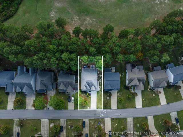 an aerial view of residential house with outdoor space and trees all around