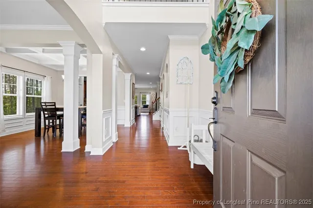 a hallway with wooden floor table and chairs