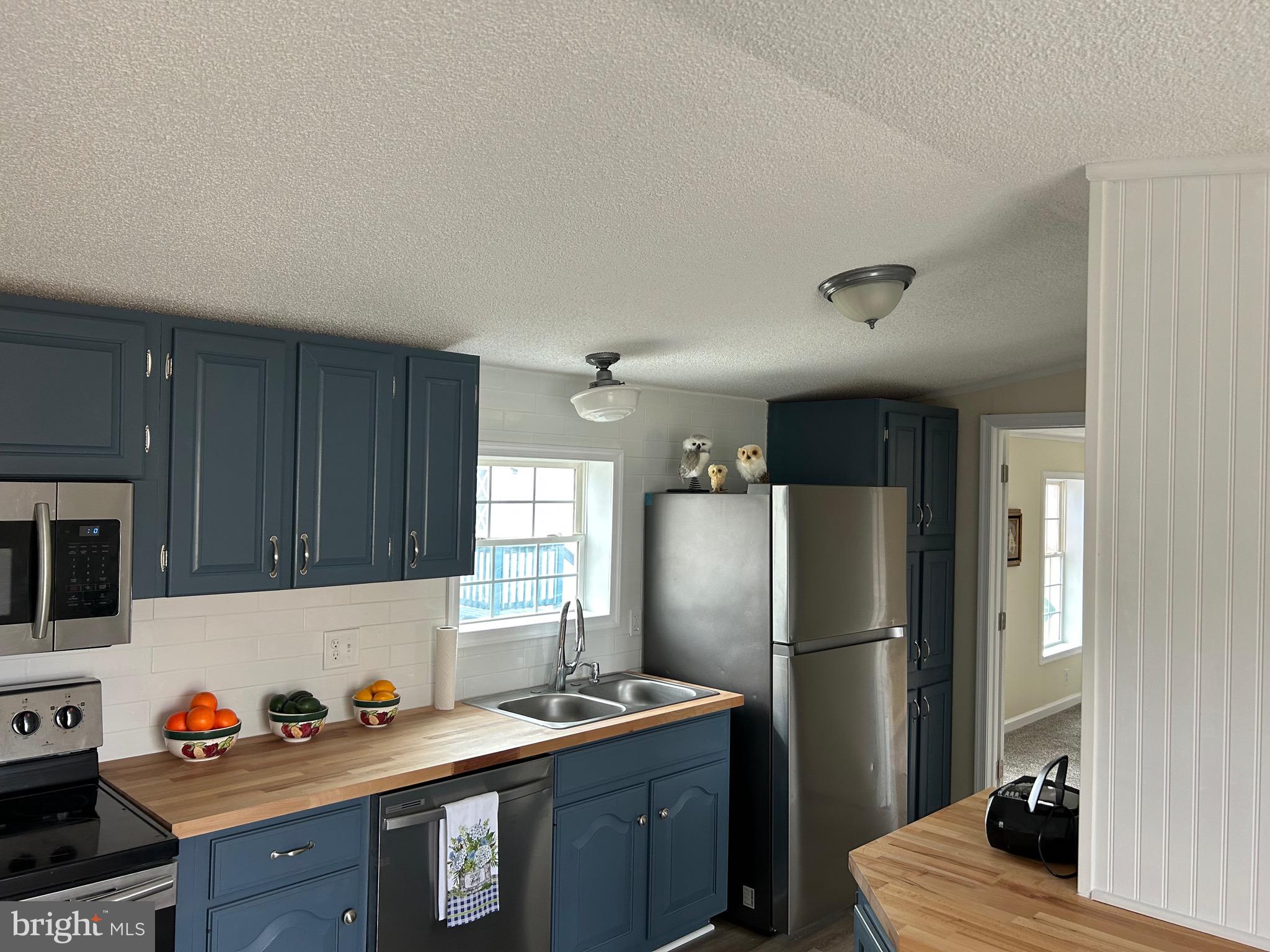 a kitchen with stainless steel appliances granite countertop a refrigerator a sink and wooden cabinets