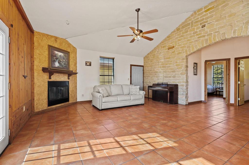 5777 State Highway 160 Whitewright, TX 75491 - Photo 16 of 36 a living room with furniture a fireplace and a flat screen tv