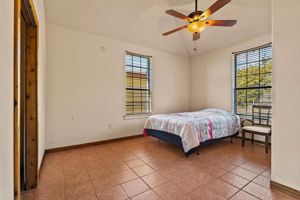 5777 State Highway 160 Whitewright, TX 75491 - Photo 22 of 36 a bedroom with a bed and a chandelier