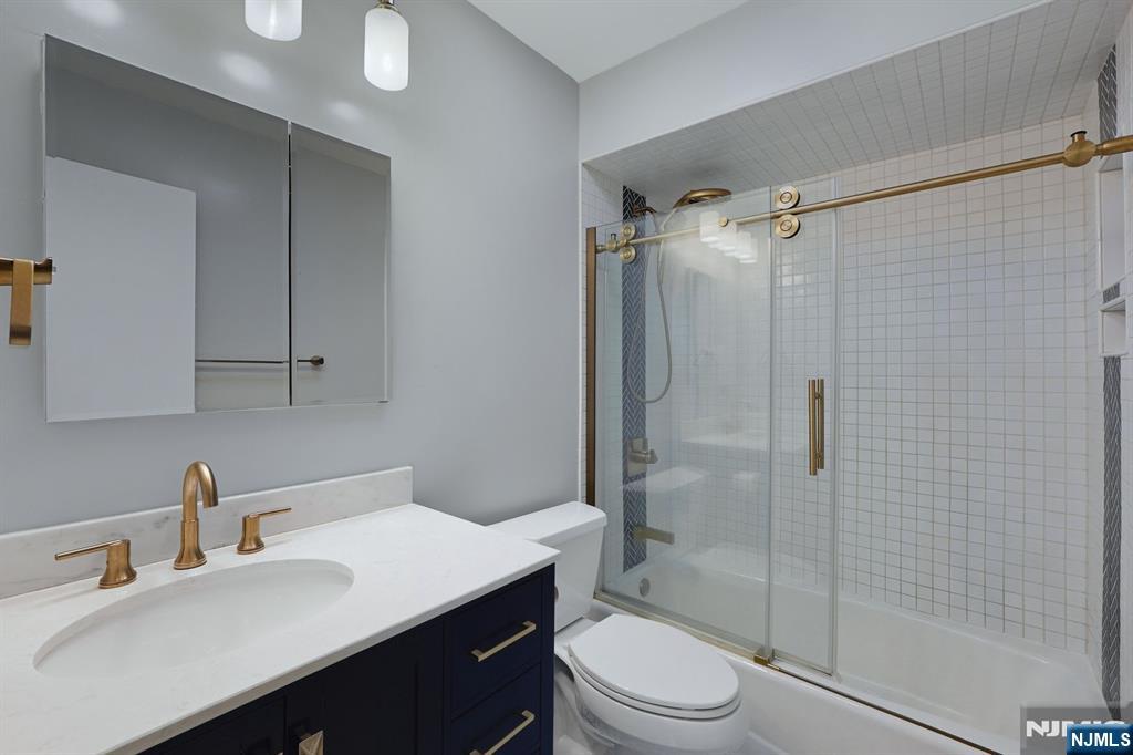 253 Park Avenue, Unit 305 Rutherford, NJ 07070 - Photo 4 of 7 a bathroom with a sink toilet a mirror and shower