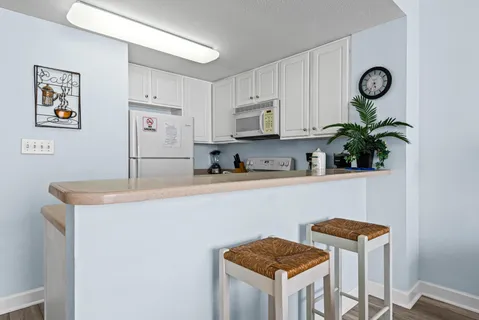 a kitchen with stainless steel appliances granite countertop a stove a sink a cabinets and a refrigerator