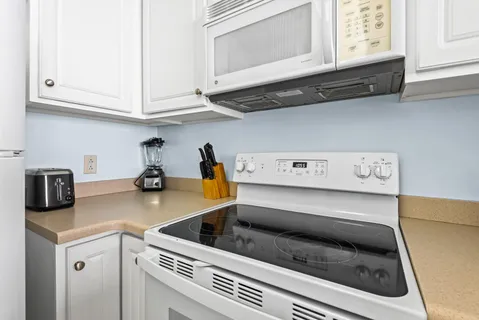 a kitchen with appliances cabinets and a stove top oven