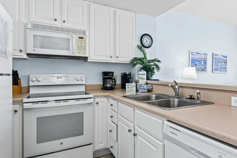 a kitchen with white cabinets a stove and a sink