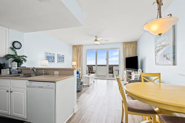 a kitchen with a stove a sink a dining table and chairs