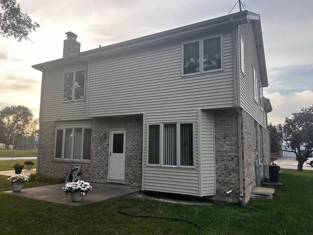 a backyard of a house with a garden and barbeque oven
