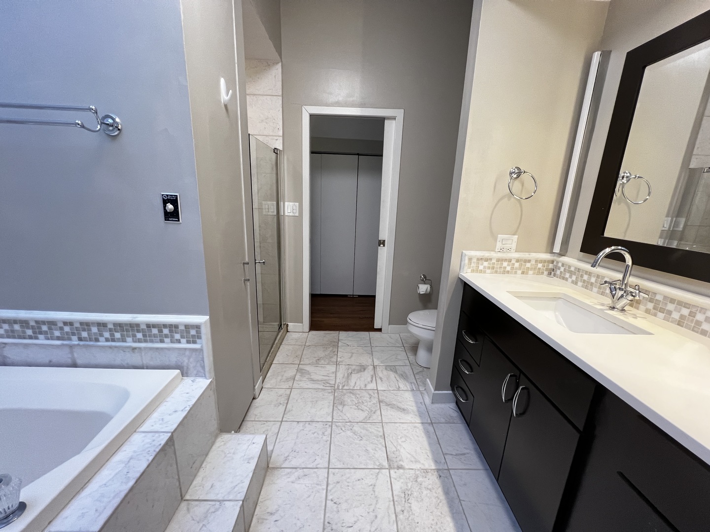 Undisclosed Address Chicago, IL 60657 - Photo 14 of 25 a spacious bathroom with a tub sink and mirror