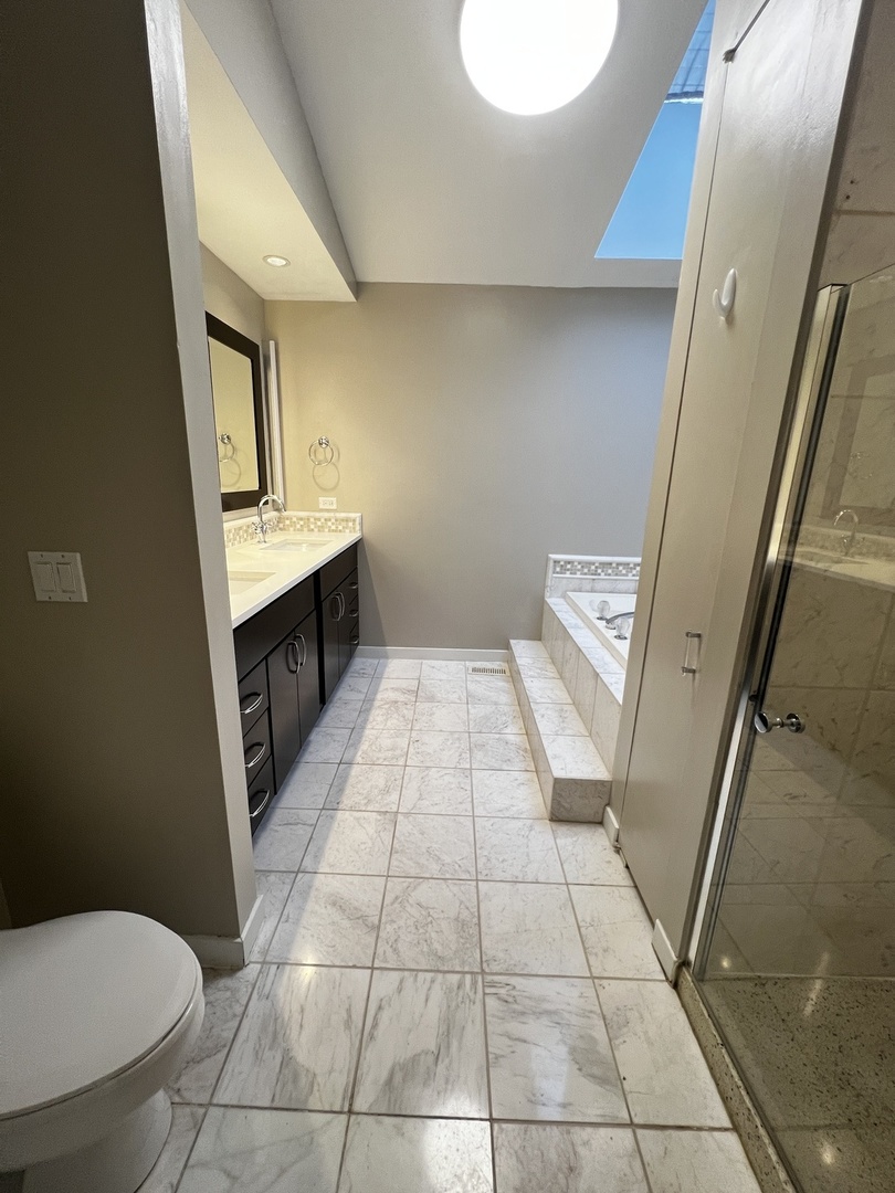 Undisclosed Address Chicago, IL 60657 - Photo 15 of 25 a bathroom with a sink a toilet and a mirror