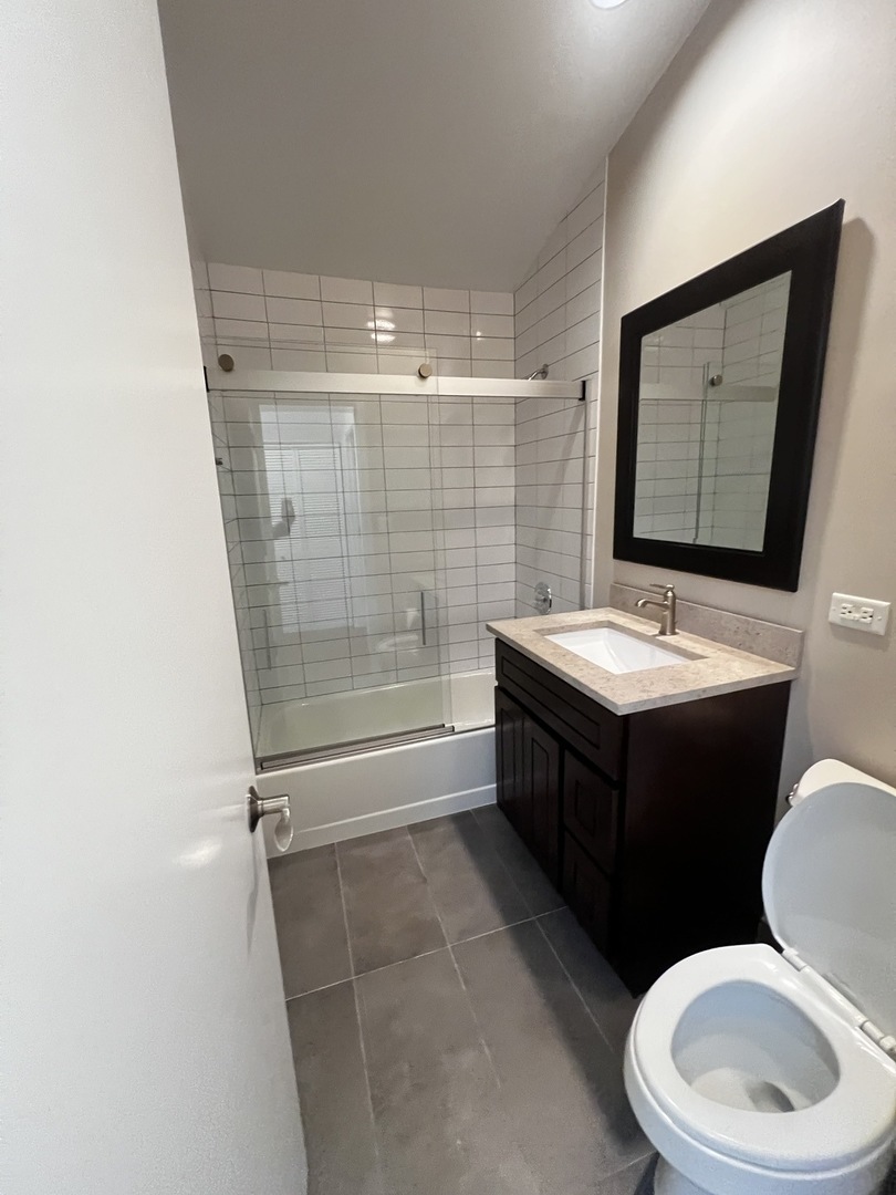 Undisclosed Address Chicago, IL 60657 - Photo 18 of 25 a bathroom with a double vanity sink toilet and shower