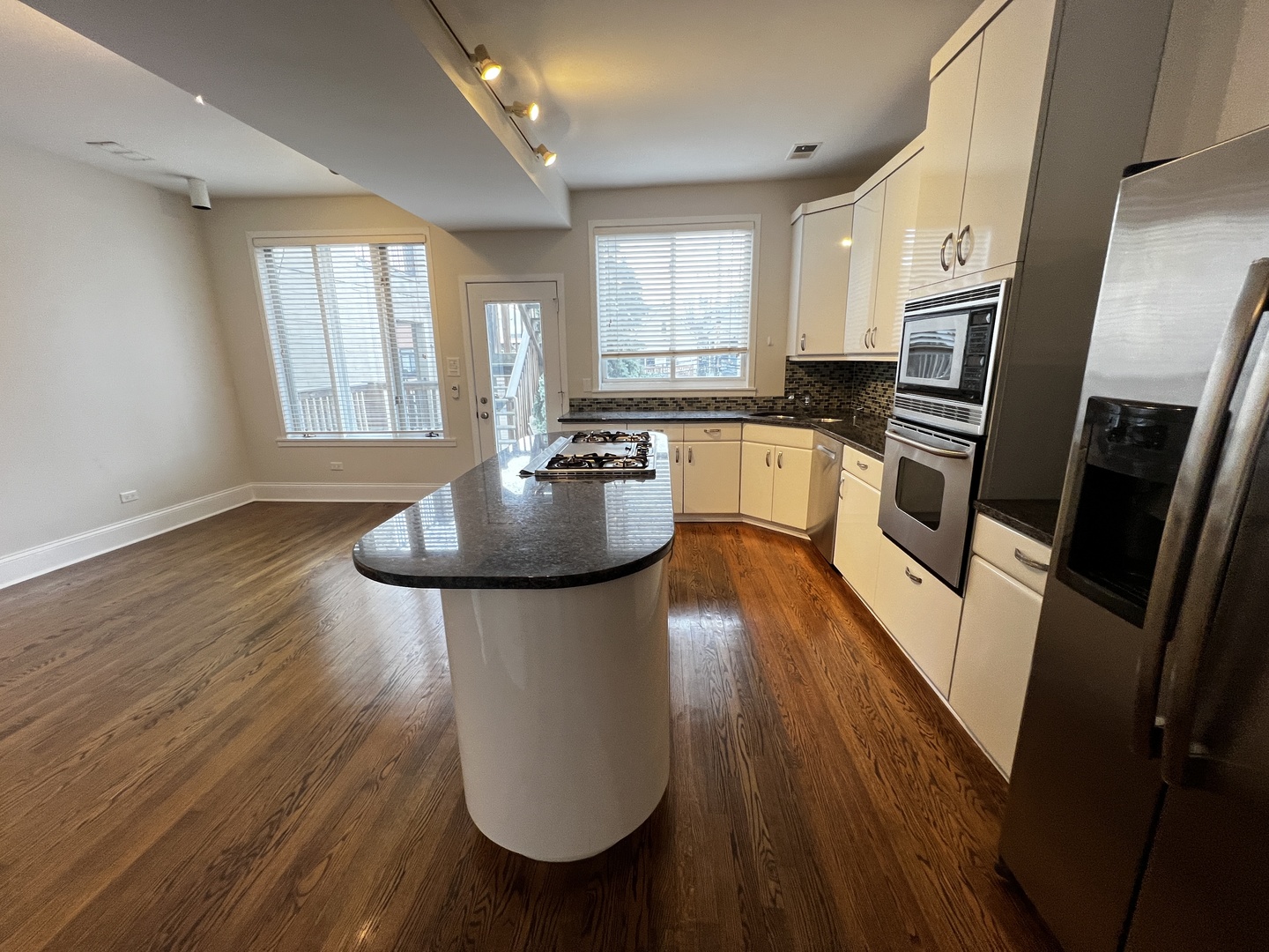Undisclosed Address Chicago, IL 60657 - Photo 2 of 25 a kitchen with stainless steel appliances granite countertop a refrigerator a stove top oven a sink dishwasher and wooden floor