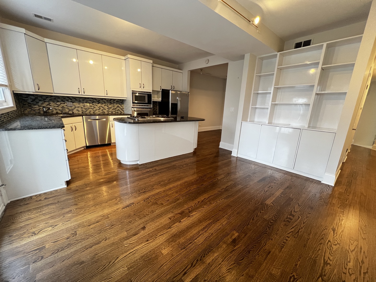 Undisclosed Address Chicago, IL 60657 - Photo 4 of 25 a kitchen with granite countertop a refrigerator and wooden cabinets