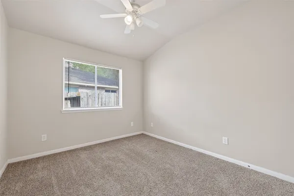 an empty room with a chandelier fan