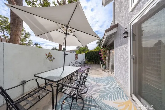 a view of a patio with a table and chairs under an umbrella