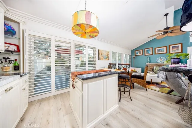 a open kitchen with stainless steel appliances granite countertop a stove top oven a dining table and chairs with wooden floor