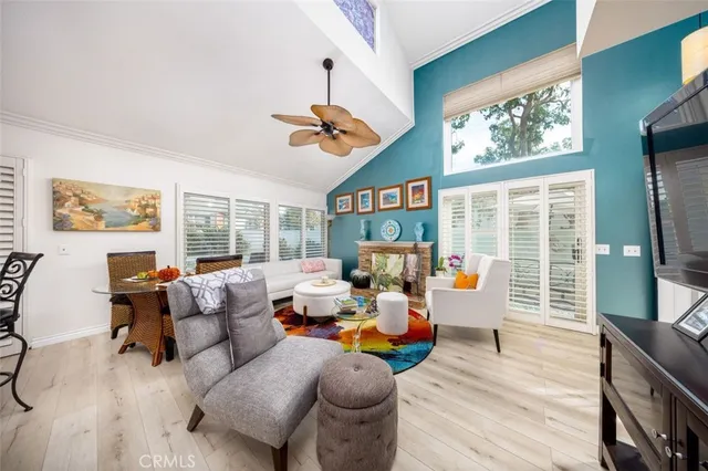 a living room with furniture large window and wooden floor