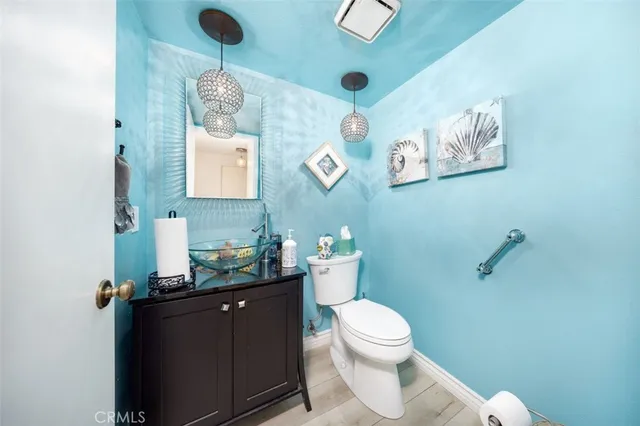 a bathroom with a granite countertop toilet sink and mirror