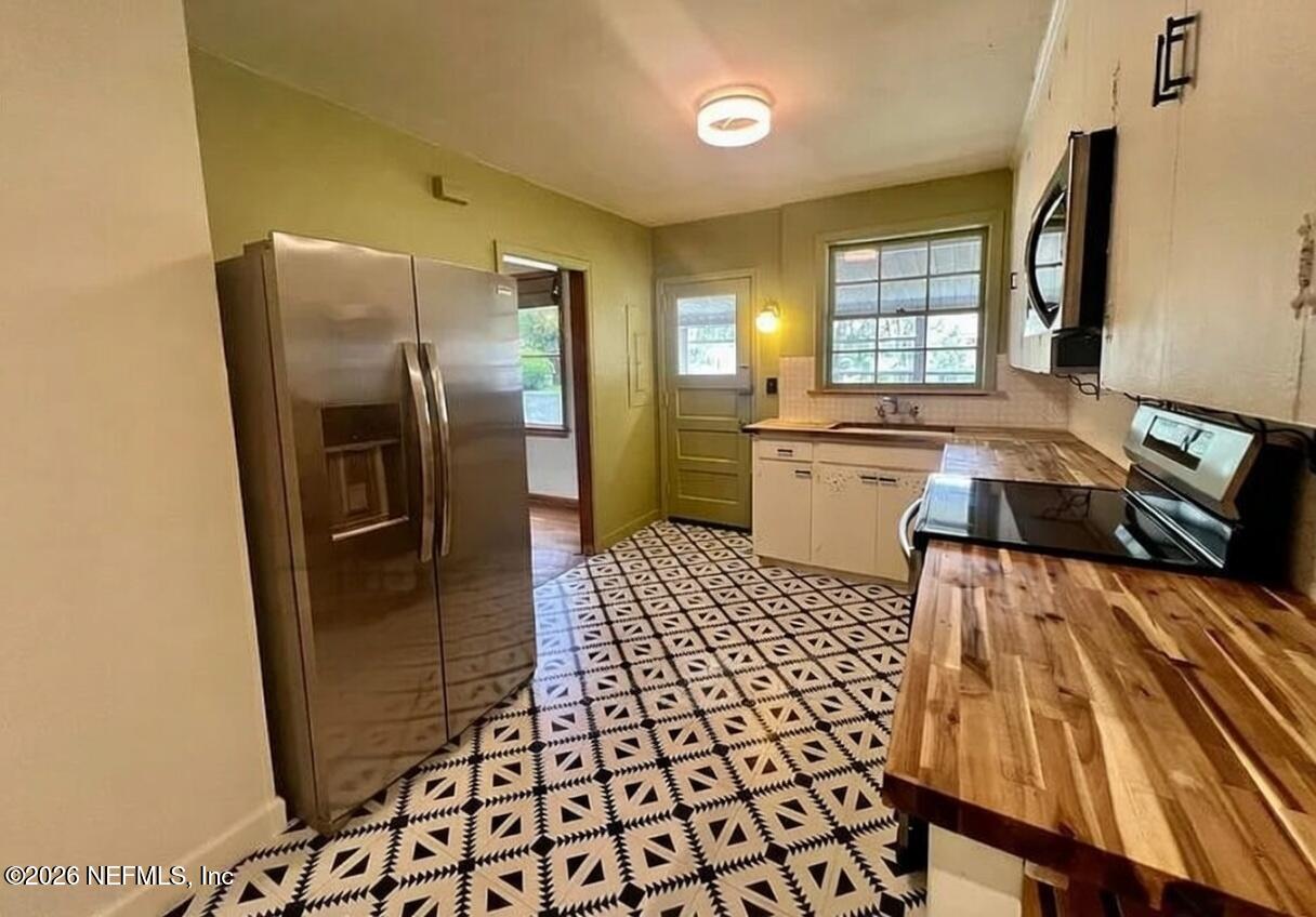 4659 Post Street Jacksonville, FL 32205 - Photo 12 of 24 a kitchen with a refrigerator sink and wooden floor