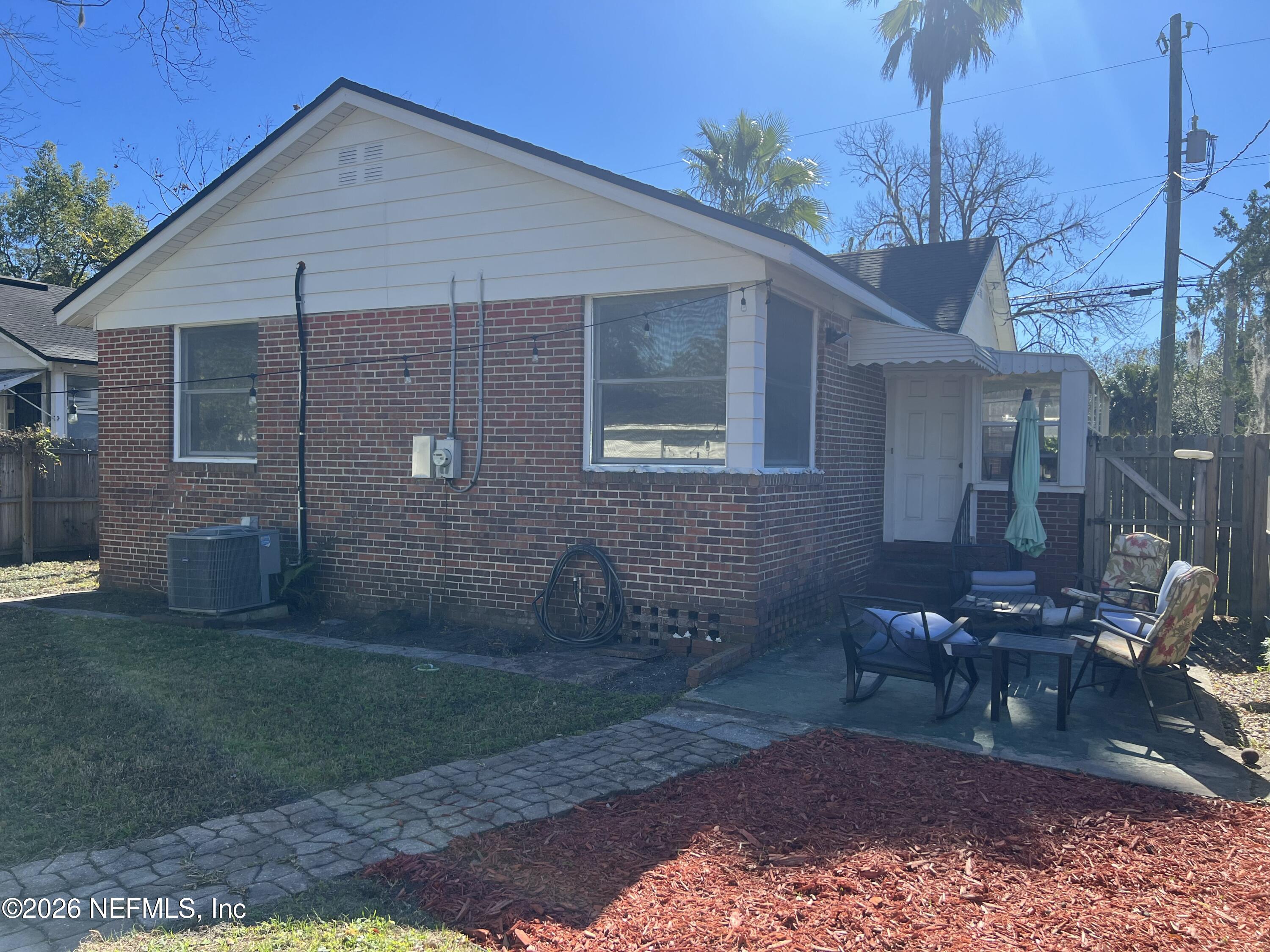 4659 Post Street Jacksonville, FL 32205 - Photo 5 of 24 a view of a backyard with table and chairs potted plants and a large tree
