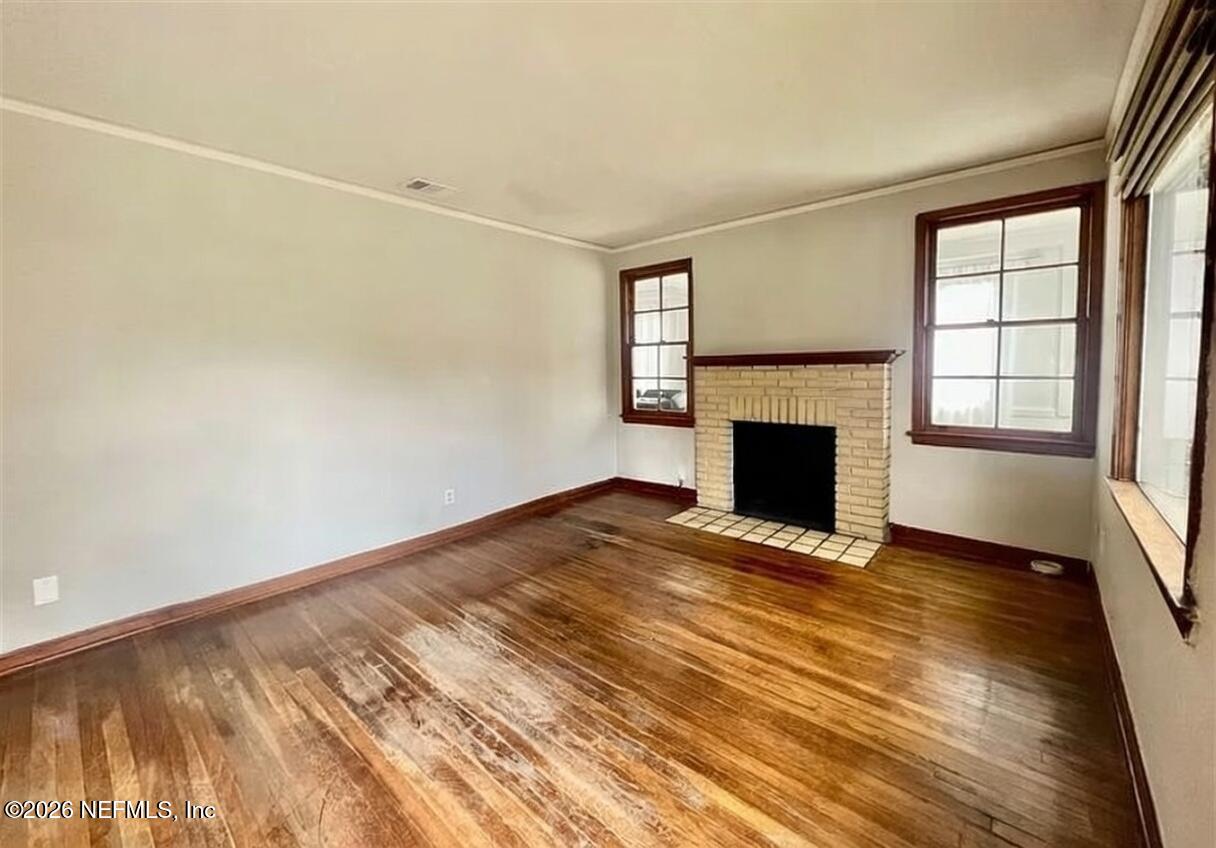 4659 Post Street Jacksonville, FL 32205 - Photo 8 of 24 an empty room with wooden floor fireplace and windows