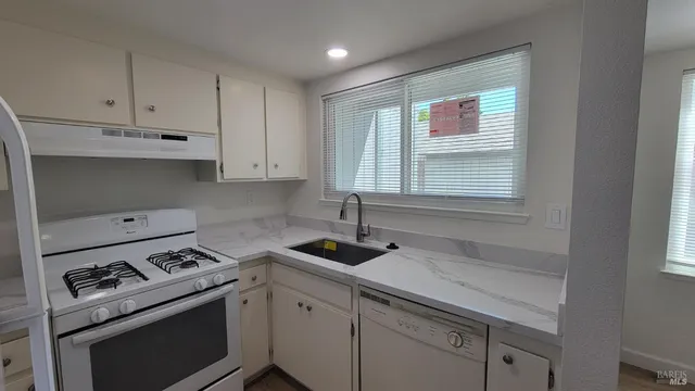 a kitchen with a sink stove and cabinets
