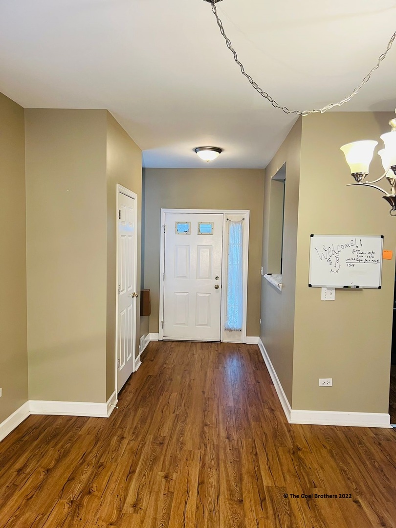 3175 Falling Waters Lane Lindenhurst, IL 60046 - Photo 5 of 19 an empty room with wooden floor and windows