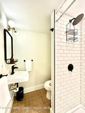 a bathroom with a sink toilet a mirror and shower