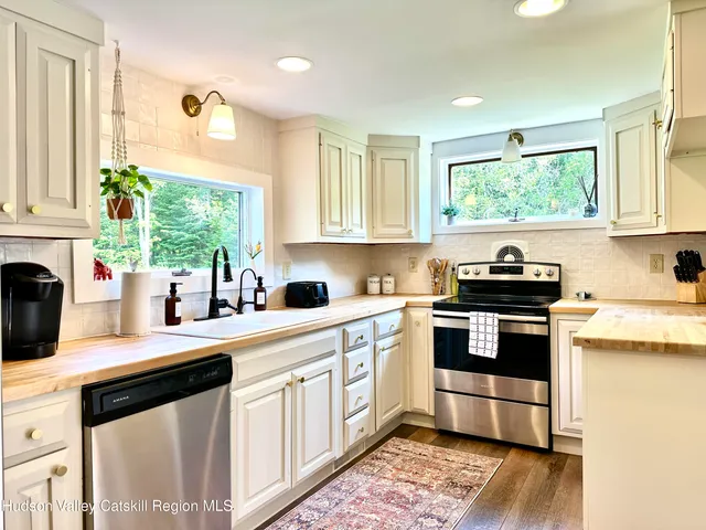 a kitchen with a stove a sink and a window