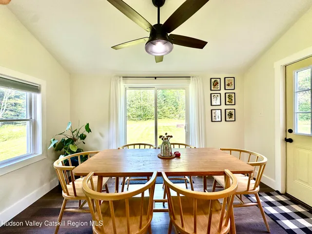 a dining room with furniture a rug and a potted plant