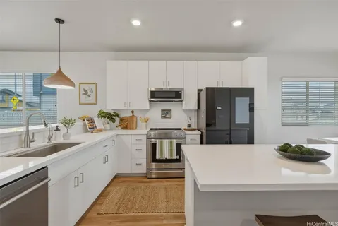 a kitchen with a sink stainless steel appliances and white cabinets