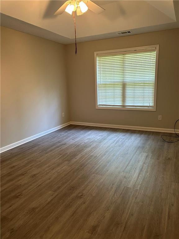 1140 Katie Lynne Lane Dacula, GA 30019 - Photo 6 of 6 an empty room with wooden floor chandelier fan and windows