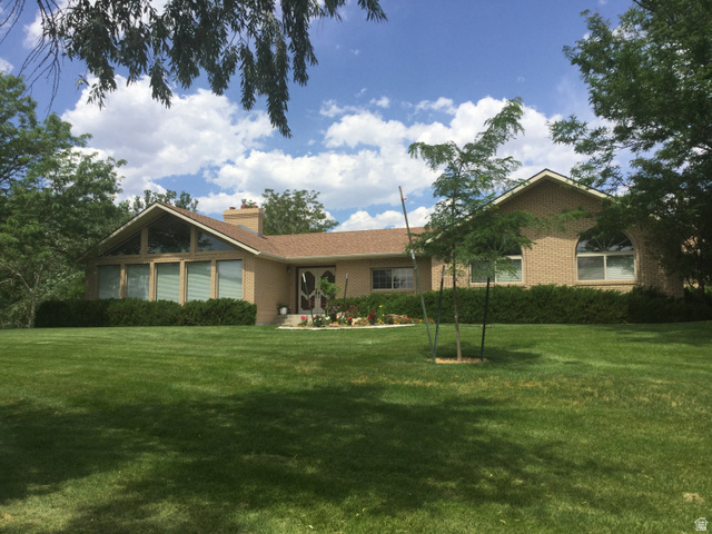 1040 West Mill Road Ferron, UT 84523 - Photo 2 of 117 Expansive green lawn with mature trees and shrubbery
