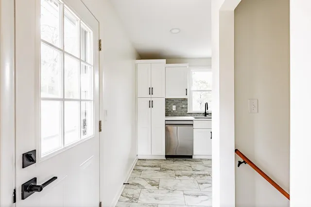 a kitchen with white cabinets and refrigerator