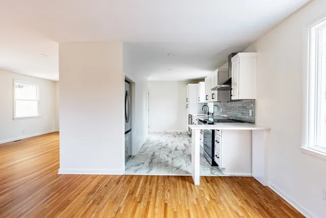 a kitchen with wooden floors and white appliances