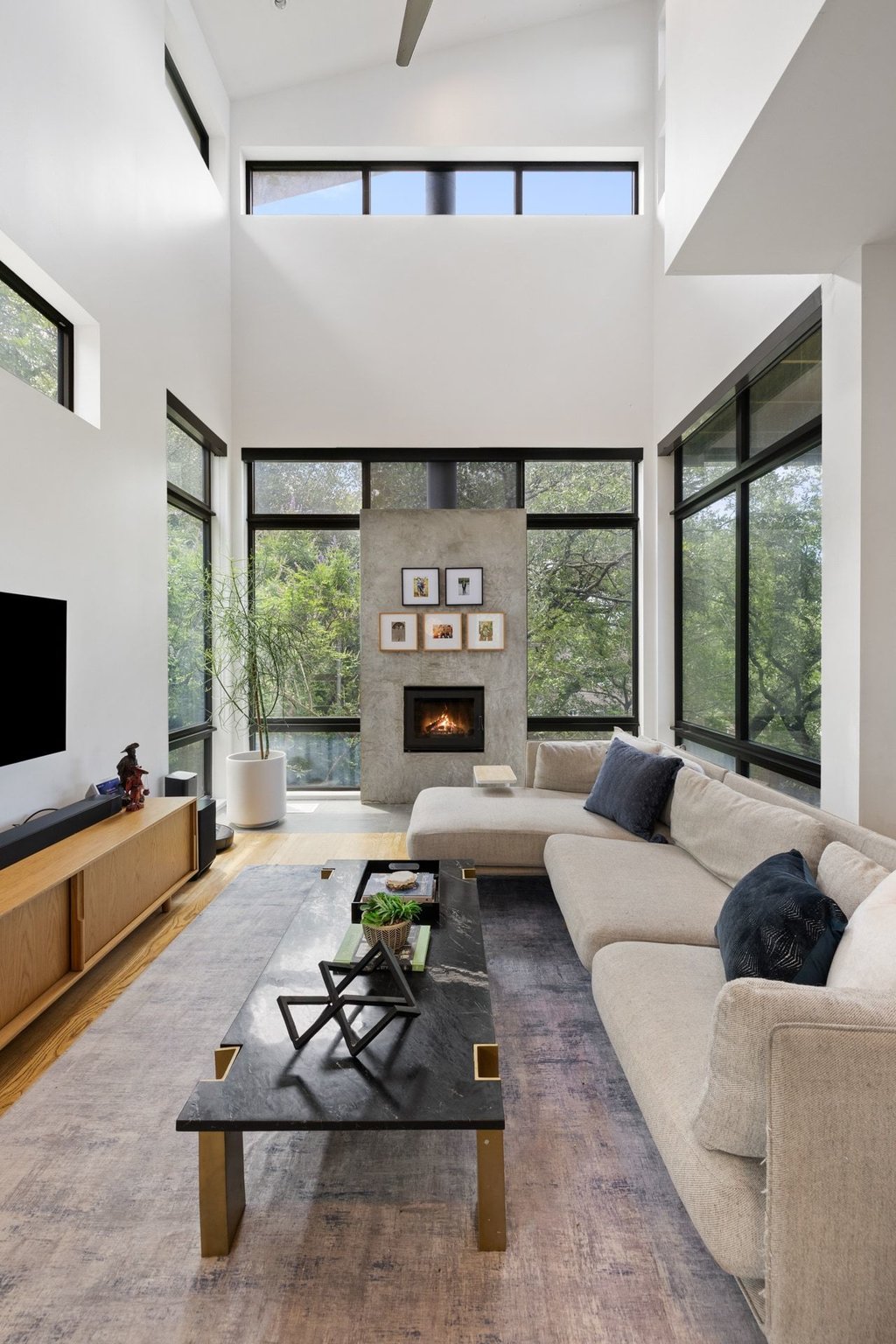 801 The High Road Austin, TX 78746 - Photo 7 of 40 a living room with furniture fireplace and large windows