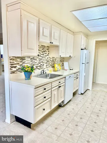 a kitchen with stainless steel appliances a sink window and cabinets