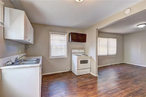 a kitchen with wooden floors and appliances