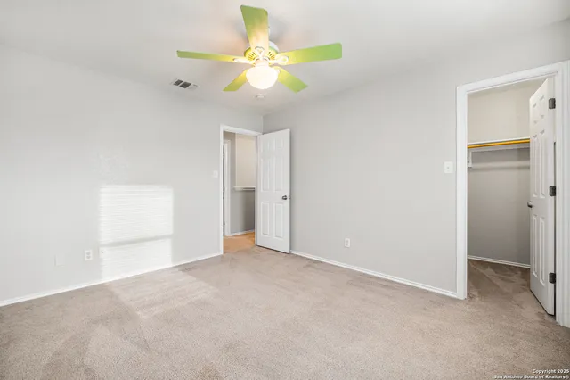 an empty room with closet and fan