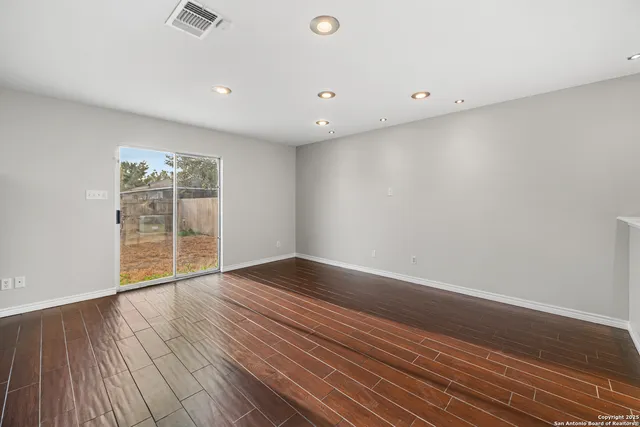 a view of an empty room with wooden floor