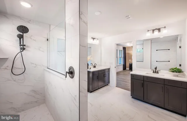 a bathroom with a double vanity sink mirror and shower