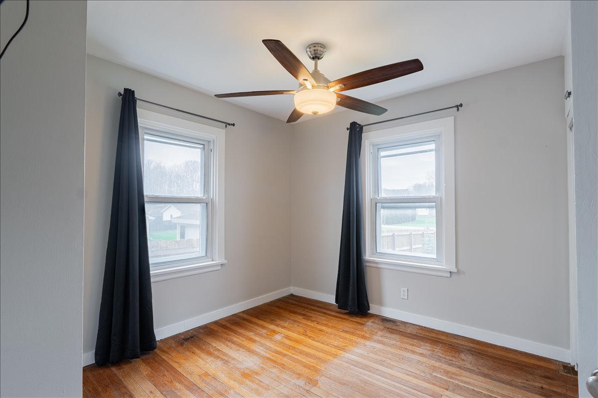 8 Felton Place Bloomington, IL 61701 - Photo 15 of 31 an empty room with wooden floor ceiling fan and windows