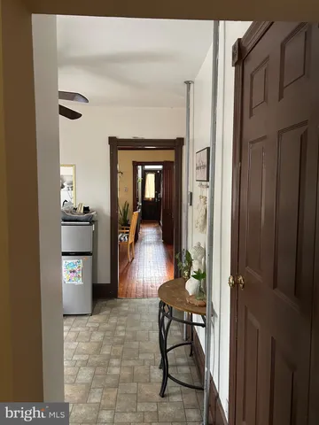 a view of a hallway to a livingroom and a dining room with furniture