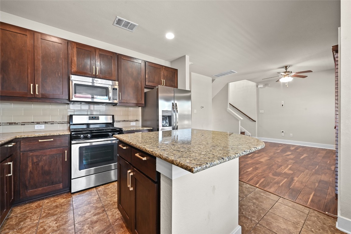 1504 Lorraine Loop, Unit B Austin, TX 78758 - Photo 11 of 25 a kitchen with stainless steel appliances granite countertop a sink stove and cabinets
